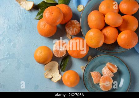 Fruits frais de mandarine avec feuilles du verger.Jardinage à la maison.mandarine entière et tranches bio.Couleur orange. Banque D'Images