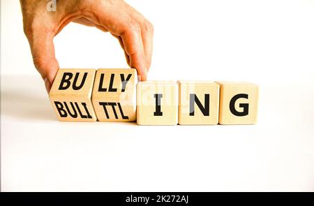 Bullying and belittling symbol. Concept words Bullying and Belittling on wooden cubes. Businessman hand. Beautiful white table white background. Busin Stock Photo