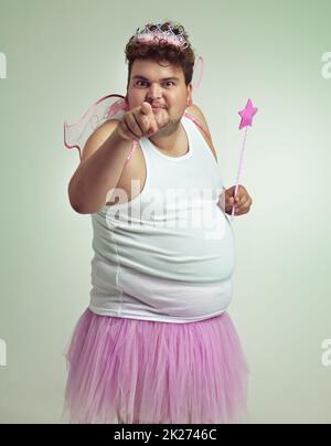 J'ai quelque chose pour vous.Un homme en surpoids dans un costume de fée rose pointant vers l'appareil photo. Banque D'Images