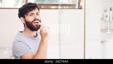 Restez au frais et soyez à votre meilleur look.Photo d'un beau jeune homme chantant tout en se brossant les dents à la maison. Banque D'Images