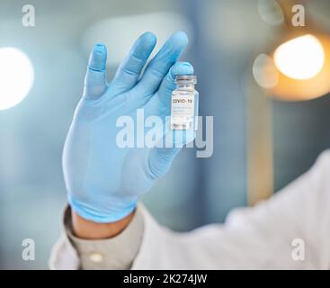 Il est temps de prendre une photo de rappel.Injection de culture d'un médecin tenant un tube de vaccin. Banque D'Images