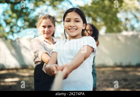 C'est vrai, les filles sont super fortes.Prise de vue d'un groupe d'adolescents jouant un jeu de remorqueurs de guerre au camp d'été. Banque D'Images