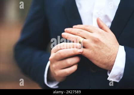 Il est prêt à nouer le nœud.Photo courte d'un marié méconnaissable qui ajuste son anneau le jour de son mariage. Banque D'Images