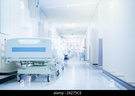 Là où la guérison se produit.Photo d'un lit d'hôpital dans un couloir vide d'un hôpital moderne. Banque D'Images