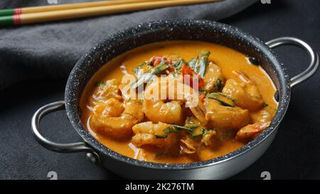 Crevettes thaïlandaises au curry rouge.Soupe de curry rouge traditionnelle thaïlandaise avec crevettes et lait de coco.Curry Panaeng et arrière-plan sombre. Banque D'Images