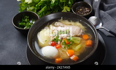 Soupe de nouilles de poulet au Caldo de Gallina avec œufs durs et herbes.La soupe péruvienne classique de nouilles de poulet. Banque D'Images