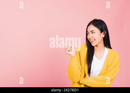 une femme se tenant en pointant du doigt vers l'extérieur pour présenter le produit Banque D'Images