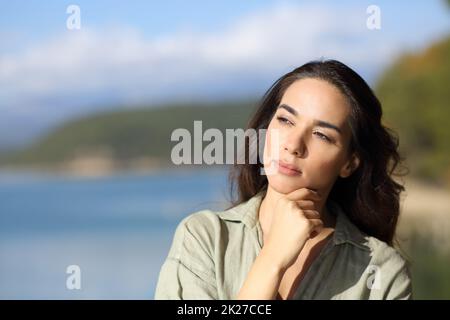 Femme pensive pensant à côté dans un lac Banque D'Images