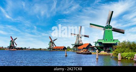 Moulin à vent hollandais dans la campagne verte près d'Amsterdam, pays-Bas, avec ciel bleu et eau de rivière. Banque D'Images