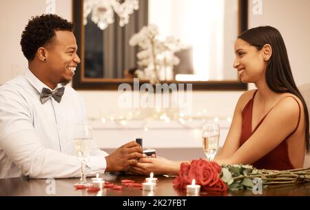 Engagement, proposition sonnent et couple le jour au restaurant avec roses, cadeau et célébration d'amour. Bijoux dans les mains, les femmes ou les personnes de jeunes hommes noirs Banque D'Images