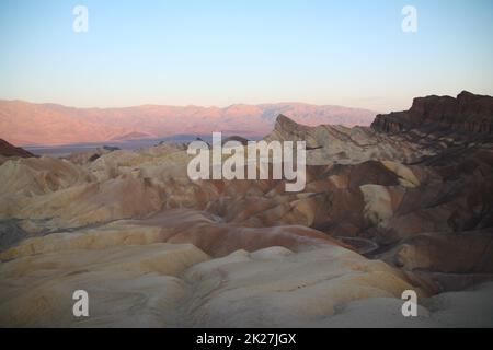 Le soleil se lève derrière les couleurs de Zabriskie point dans le désert de la Vallée de la mort Banque D'Images