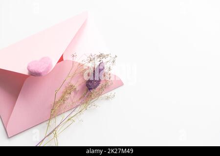 Flat lay on a soft pink background envelope with hearts. Valentine's day and wedding concept. Declaration of love Stock Photo