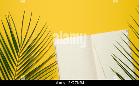 ouvrez le bloc-notes avec des feuilles blanches vierges sur fond jaune, vue de dessus. Banque D'Images