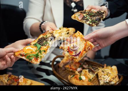 Les membres de l'équipe mangent de la pizza Banque D'Images