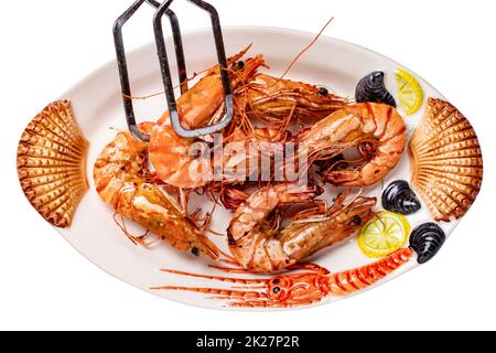 Gros plan de grosses crevettes tigrées ou crevettes sur une assiette colorée de fruits de mer isolée sur un fond blanc. Concept d'alimentation saine. BARBECUE. Masque. Fond de fruits de mer. Publicité spatiale. Banque D'Images