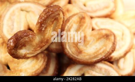 Pâte fraîche feuilletée biscuits de palme en forme de coeur. Pâtisseries françaises classiques. Oreille de porc, biscuits d'oreille d'éléphant, coeurs français. Vue de dessus Banque D'Images