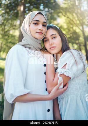 Femme musulmane, amis et confiance tout en se tenant dehors dans un parc et la nature avec le soutien, l'amour et une bonne relation. Portrait arabe moyen-oriental Banque D'Images