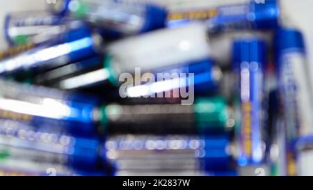 Piles aléatoires multicolores défocacées sur une table AA, vue du dessus. Banque D'Images