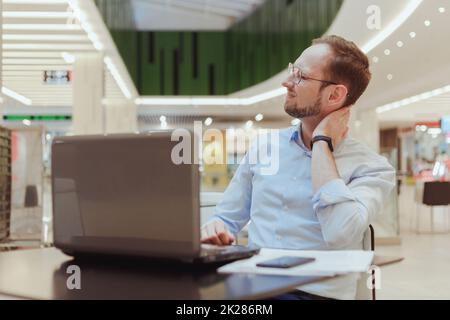 Gros plan portrait d'un malheureux stressé, jeune homme avec une très mauvaise douleur au cou, après de longues heures de travail, étudiant, isolé fond blanc. Émotions humaines négatives, expression faciale, sensation Banque D'Images