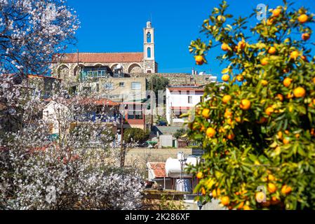 Chypre, église du village de Kellaki vue à travers les amandiers et les orangers Banque D'Images