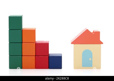 petite maison de jouets et blocs de construction colorés en bois sur fond blanc Banque D'Images