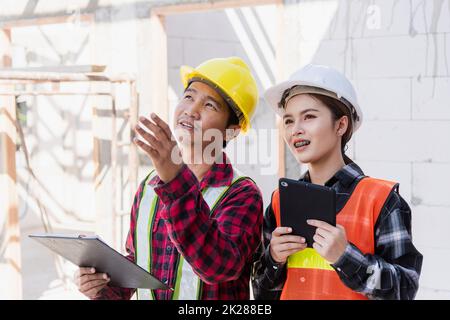 Homme et femme de contremaître d'ingénieur asiatique travaillant sur le chantier de construction de bâtiments Banque D'Images