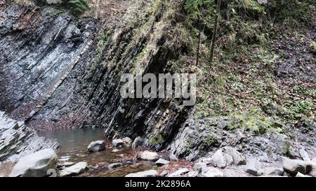 Cascades dans un petit canyon avec des murs en pierre. Belle cascade dans les montagnes. rivière dans les Carpates dans la forêt d'automne de montagne. vue panoramique, le mouvement de l'eau. Banque D'Images