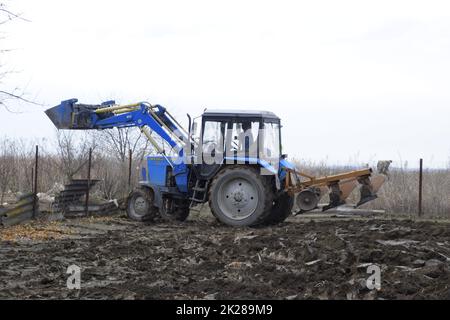 Le tracteur laboure le jardin. Labourer le sol dans le jardin Banque D'Images