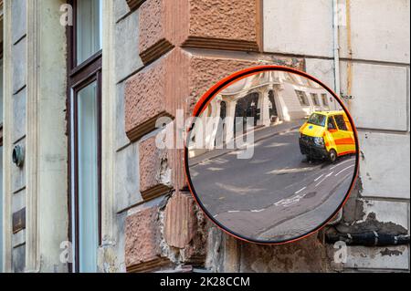 miroir de signalisation avec une ambulance jaune, voiture d'urgence garée sur le côté de la rue Banque D'Images