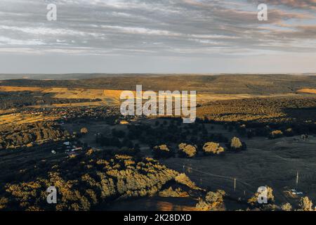 Vue aérienne sur les terres agricoles et les forêts d'Europe. Belle campagne roumaine avec champs de vert émeraude et prairies. Banque D'Images