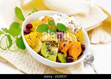 Salade de fruits aux canneberges et à la crème dans un bol en bois Banque D'Images