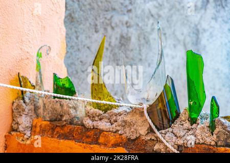 Dangereux mur avec des bouteilles de verre cassées Playa del Carmen Mexique. Banque D'Images