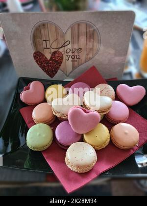 Concept de la Saint-Valentin. Pâtisseries françaises de macaron avec fleurs Banque D'Images