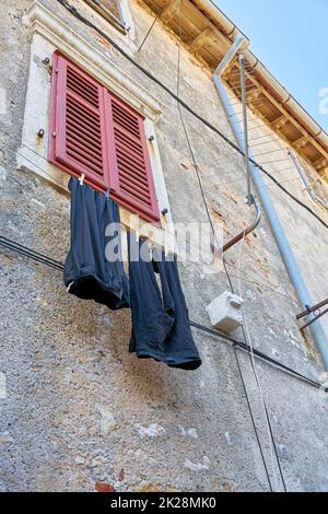 Corde à linge avec pantalon sur une façade dans la vieille ville de Krk en Croatie Banque D'Images