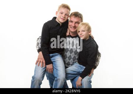 Portrait en demi-longueur d'un père et de deux fils en vêtements décontractés sur fond blanc Banque D'Images