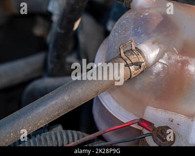 Collier métallique pour fixer le flexible en caoutchouc du réservoir en plastique du liquide de refroidissement de la voiture. Banque D'Images