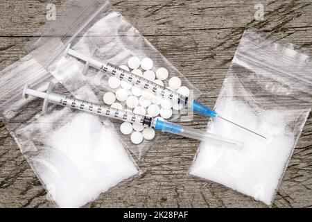Seringue d'injection de drogue et héroïne cuite dans un sac sur une table en bois grundy Banque D'Images