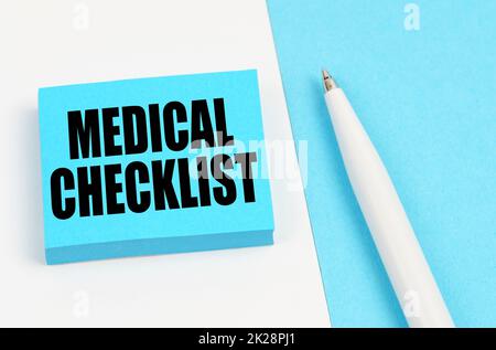 Medical concept. On a white and blue surface, a pen and blue stickers with the inscription - MEDICAL CHECKLIST Stock Photo