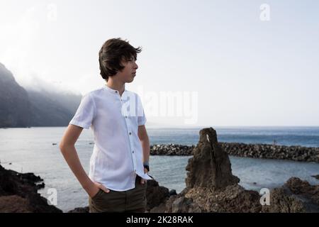 Portrait d'un adolescent sur la toile de fond des falaises de Los Gigantes. Ténérife. Îles Canaries. Espagne. Banque D'Images