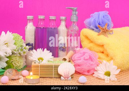 Produits de bain et de spa avec fleurs sur savon de fond rose Banque D'Images