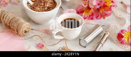 Tasse à café près des fleurs roses sur une table blanche Banque D'Images