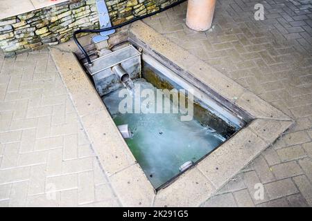 Une petite piscine avec eau de la source. Une niche dans le sol pour le recrutement d'eau d'une source Banque D'Images
