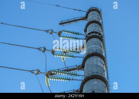 Prend en charge les lignes électriques à haute tension contre le ciel bleu Banque D'Images