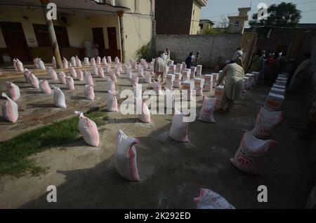 Peshawar, Pakistan. 22nd septembre 2022. Les personnes touchées par les inondations reçoivent une aide de secours distribuée par la Fondation Al Khidmat dans le district de Nowshera, dans le village de Garhi Momin, dans la province de Khyber Pakhtunkhwa. (Photo de Hussain Ali/Pacific Press) crédit: Pacific Press Media production Corp./Alay Live News Banque D'Images