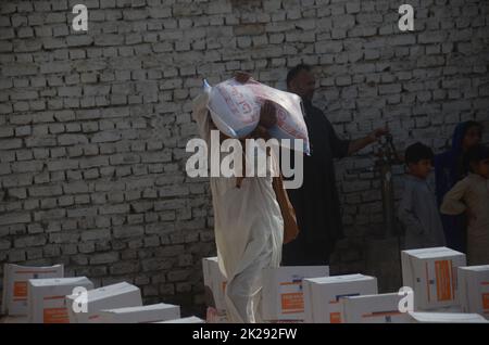 Peshawar, Pakistan. 22nd septembre 2022. Les personnes touchées par les inondations reçoivent une aide de secours distribuée par la Fondation Al Khidmat, dans le district de Nowshera, dans le village de Garhi Momin, dans la province de Khyber Pakhtunkhwa. (Photo de Hussain Ali/Pacific Press) crédit: Pacific Press Media production Corp./Alay Live News Banque D'Images