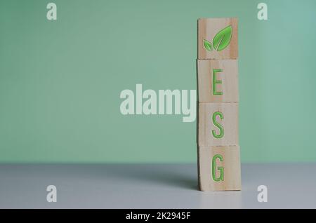 Cubes en bois avec le symbole esg gouvernance sociale environnementale sur fond vert et espace de copie. Banque D'Images