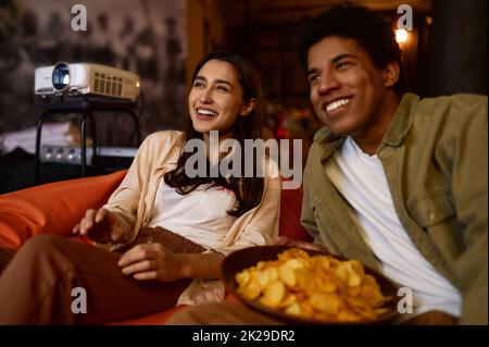 Un couple familial regardant un projecteur à la maison Banque D'Images