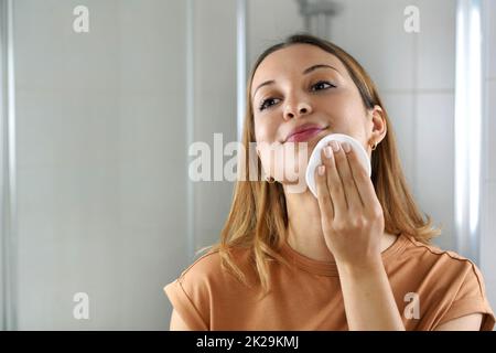 Tampon de coton écologique. Portrait d'une jeune femme utilisant des tampons en coton respectueux de l'environnement pour enlever le maquillage. Copier l'espace. Banque D'Images