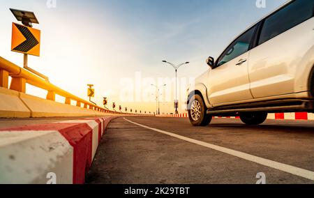 Route en béton courbe avec signalisation routière courbe et panneau rouge-blanc d'arrêt interdit. Panneau solaire énergie sur courbe signalisation routière. Voyage en voiture. Flou de mouvement de la conduite de voiture blanche sur la route. Voyage en voiture l'été. Banque D'Images