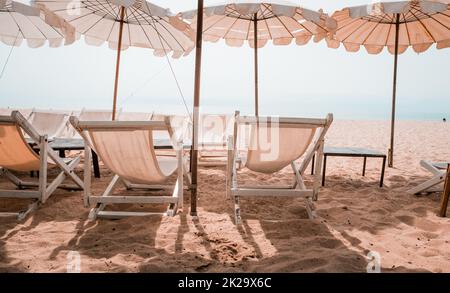 Transats et parasol blancs sur la plage tropicale. Parasol blanc sur la plage en été Banque D'Images